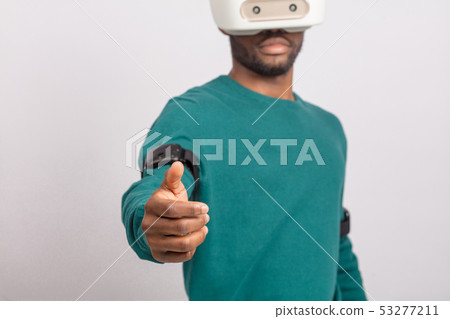 African man wears virtual reality goggles, holds game controllers, isolated African man wears virtual reality goggles, holds game controllers, isolated 53277211