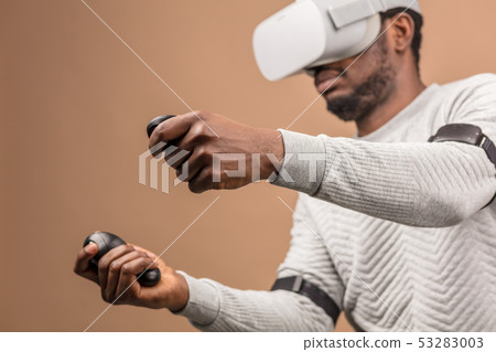 Black man wearing 3d vr glasses, playing videogame, holding joystick in hands 53283003