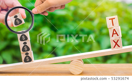 A hand puts wooden blocks with dollars on scales 53291674