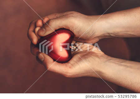 Red heart in man's hands, view from above 53295786