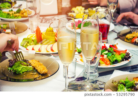glasses of champagne on the table with food 53295790