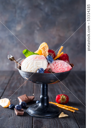 Set of ice cream scoops of different colors and flavours with berries, chocolate on dark background Set of ice cream scoops of different colors and flavours with berries, chocolate on dark background 53314285