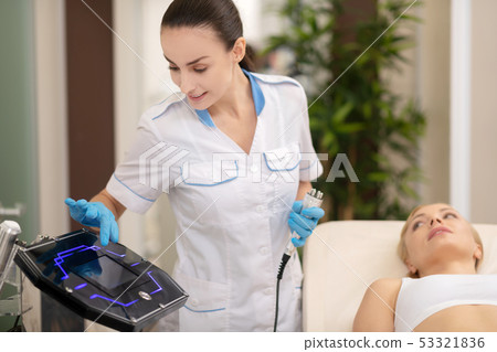 Dermatologist providing ultrasound skin treatment for client Dermatologist providing ultrasound skin treatment for client 53321836