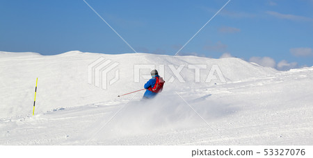 Skier downhill on snowy ski slope in sun winter 53327076