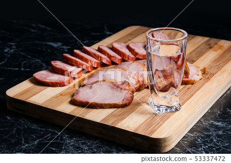 Shot glasses with vodka, slices of smoked meat and Shot glasses with vodka, slices of smoked meat and 53337472