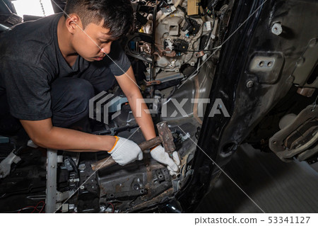 The mechanic is repairing the car 53341127