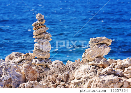 Zen pyramid of rough stones on the blurred sea 53357864