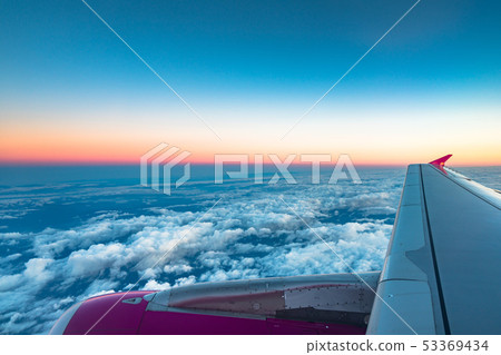 Sunrise view from the window of an airplane flying Sunrise view from the window of an airplane flying 53369434
