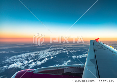Sunrise view from the window of an airplane flying Sunrise view from the window of an airplane flying 53369439