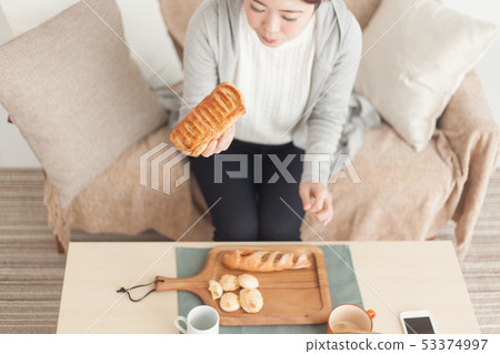 A woman eating bread 53374997
