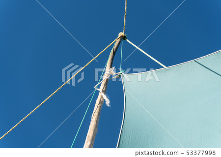 Detail on pirogue - small boat used in Madagascar - mainsail jib blea sky in background 53377998