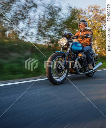 Motorcycle driver riding in Alpine highway, Nockalmstrasse, Austria, Europe. Motorcycle driver riding in Alpine highway, Nockalmstrasse, Austria, Europe. 53400279