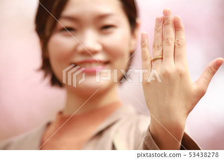 Woman showing a ring 53438278