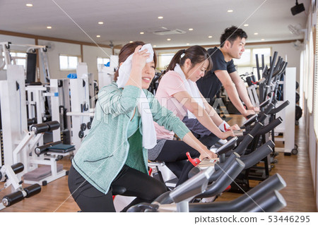 Men and women doing aerobic exercise in a gym 53446295