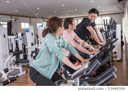 Men and women doing aerobic exercise in a gym 53446304
