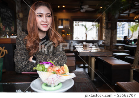 woman eating salmon sashimi spicy salad in 53562707
