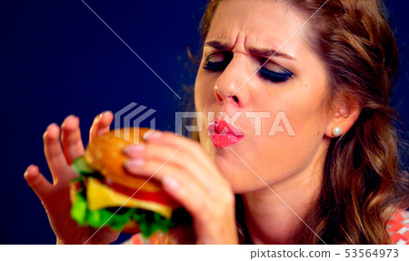 Girl eats hamburger Girl eats hamburger 53564973