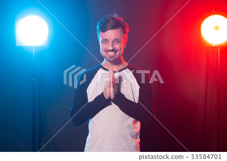 Gesture and emotions concept - Portrait of a man over the light, folded his hands 53584701