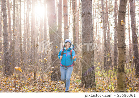People, hike and nature concept - Woman dressed in blue jacket walking in the forest 53586361