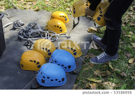 Man held helmet in hand with Safety belts with 53586956