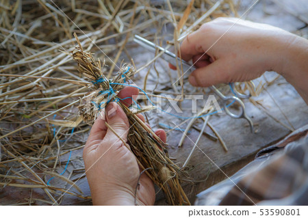 Straw toy in the form of a cross in the hands 53590801