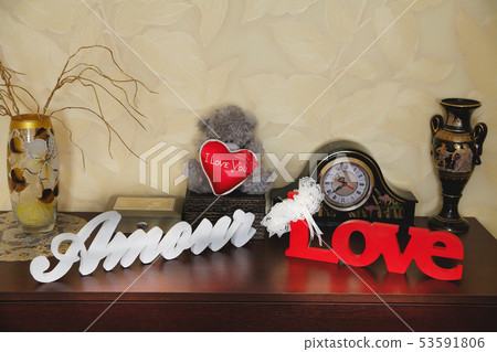 Wooden inscription with the words love in the room on the dresser 53591806