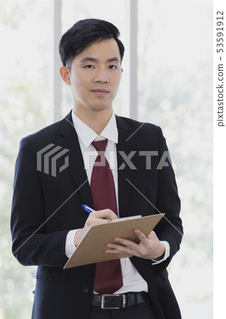 Asian Businessman standing and posing in office.. 53591912