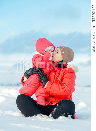 Mom and daughter pose for a winter photo shoot in snowy winter Mom and daughter pose for a winter photo shoot in snowy winter 53592165