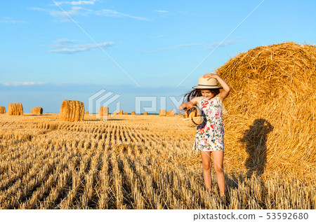 Adorable girl in rye field on sunset with a basket Adorable girl in rye field on sunset with a basket 53592680