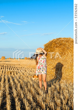 Adorable girl in rye field on sunset with a basket Adorable girl in rye field on sunset with a basket 53592682