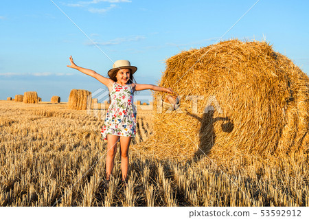 Adorable girl in rye field on sunset with a basket 53592912