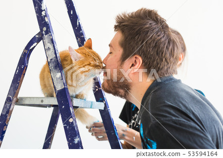 People, renovation, pet and repair concept - Portrait of funny guy with cat doing redecoration in 53594164