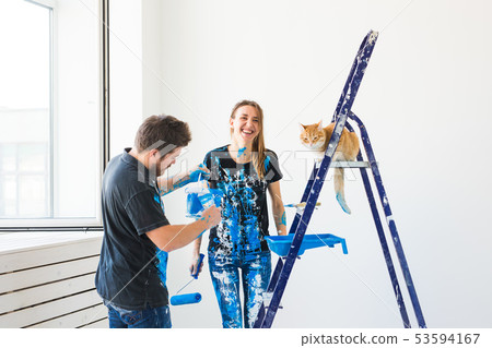 Pet, redecoration and relationship concept - Young funny couple with cat doing renovation in new Pet, redecoration and relationship concept - Young funny couple with cat doing renovation in new 53594167