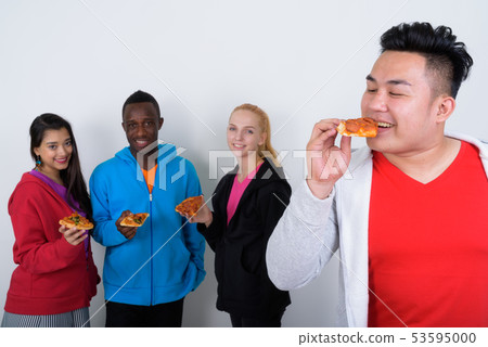 Studio shot of happy young Asian man eating and looking at slice 53595000
