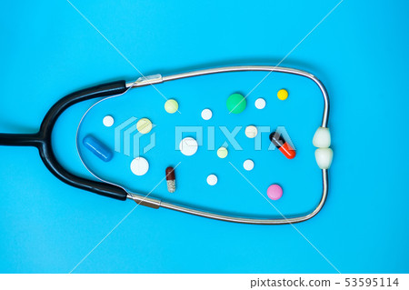 Stethoscope and pills on the blue background Stethoscope and pills on the blue background 53595114