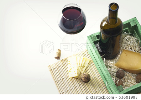 A bottle of red wine with a glass and a piece of A bottle of red wine with a glass and a piece of 53601995