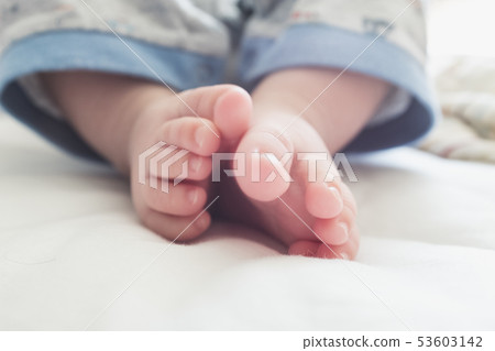 在一張白色床上的嬰孩腳 在一張白色床上的嬰孩腳 53603142