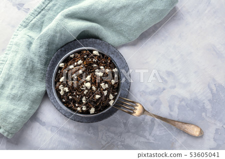 Wild black rice with a lactose-free Feta cheese, shot from the top with a fork and a place for text 53605041