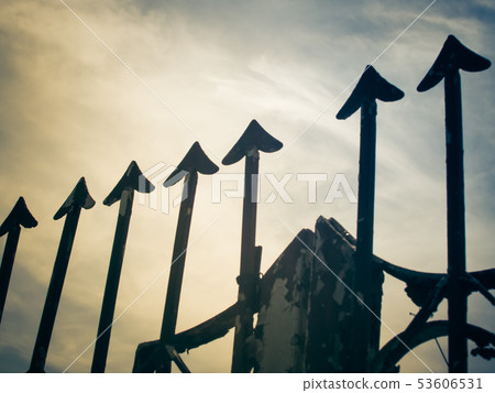 Rusty metal fence with sharp arrows 53606531