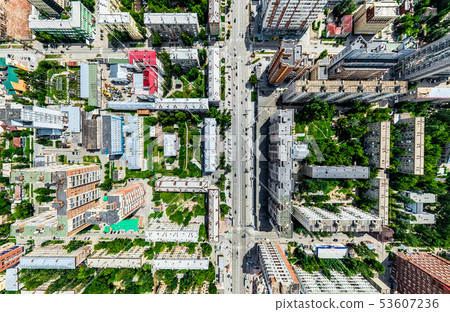 Aerial city view with crossroads and roads, houses, buildings, parks and parking lots. Sunny summer 53607236