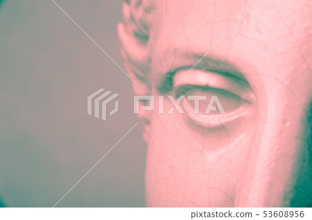 Close up face gypsum copy antique sculpture with craquelure. Red green vintage filter effect . 53608956