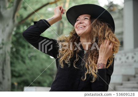 fashionable girl dressed in black shirt, hat and 53609128