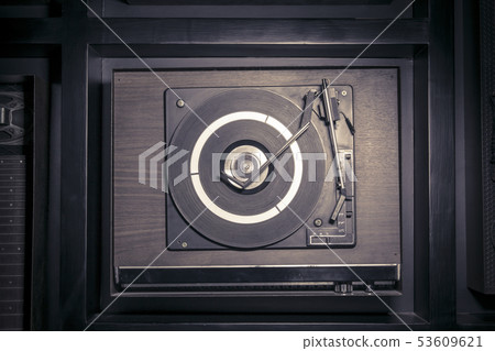 Top view of an old fashioned turntable playing a Top view of an old fashioned turntable playing a 53609621