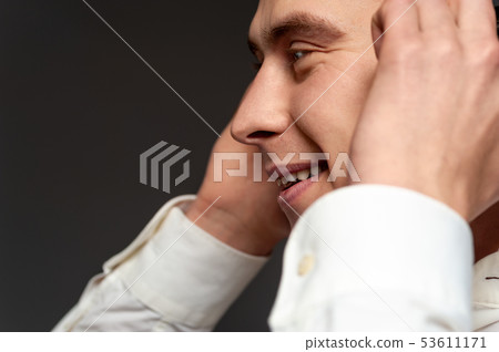 Smiling cheerful young guy with headphones Smiling cheerful young guy with headphones 53611171