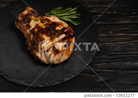 juicy piece of fried meat lies on a stone plate 53612277