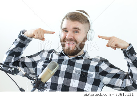 Podcasting, music and radio concept - Happy man with microphone and big headphone 53613131