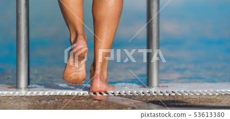 Female feet on the steps of the pool Female feet on the steps of the pool 53613380