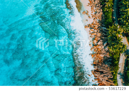 Aerial bird eye shot of tropical coastline with tropical rocky beach and palm trees at Seychelles Aerial bird eye shot of tropical coastline with tropical rocky beach and palm trees at Seychelles 53617229
