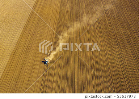 Tractor in field on a farm, aerial view Tractor in field on a farm, aerial view 53617978
