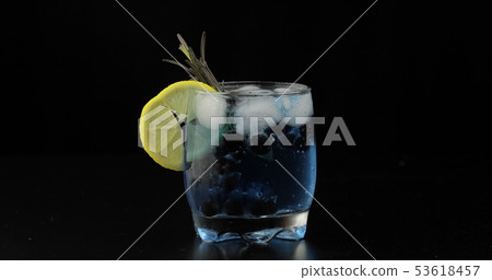 Drinking glass with cold drink. Refreshing soda lemonade blue cocktail Drinking glass with cold drink. Refreshing soda lemonade blue cocktail 53618457